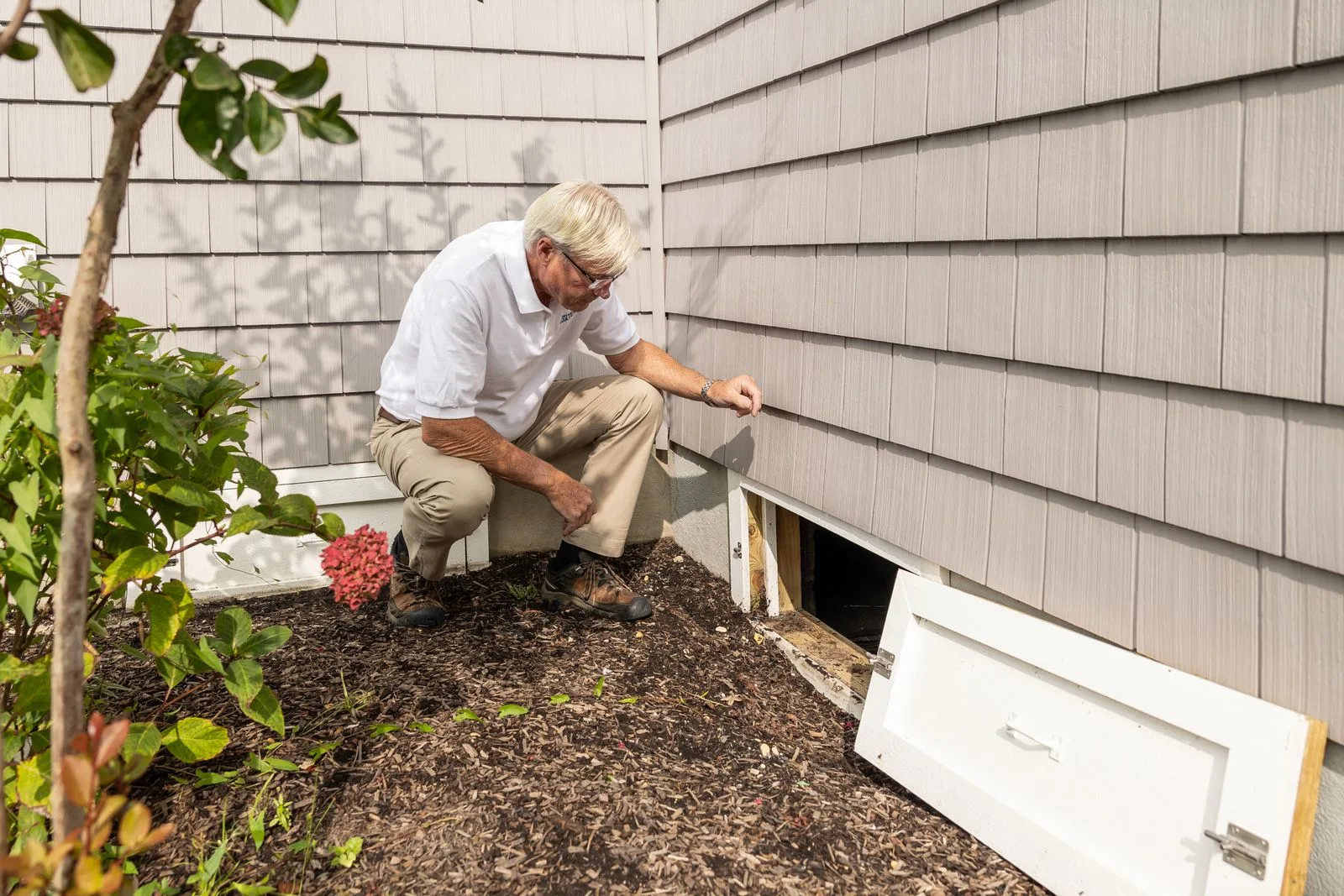 Inspector checking the foundation outside a home