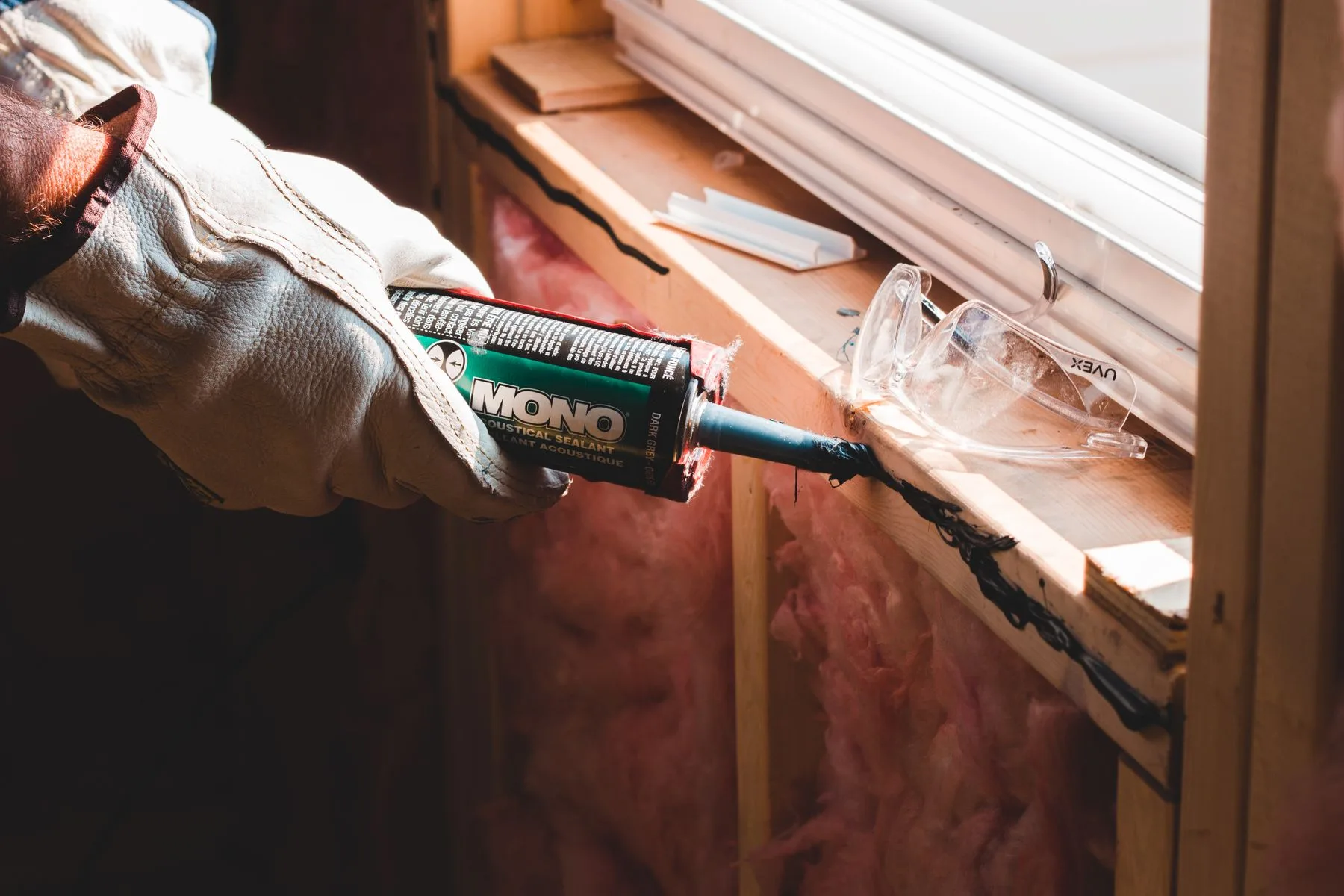 a worker sealing a gap around a window